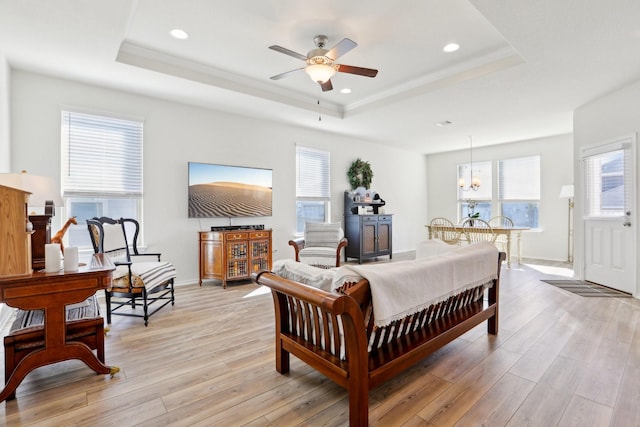 bedroom featuring light wood-type flooring, ceiling fan, and a raised ceiling