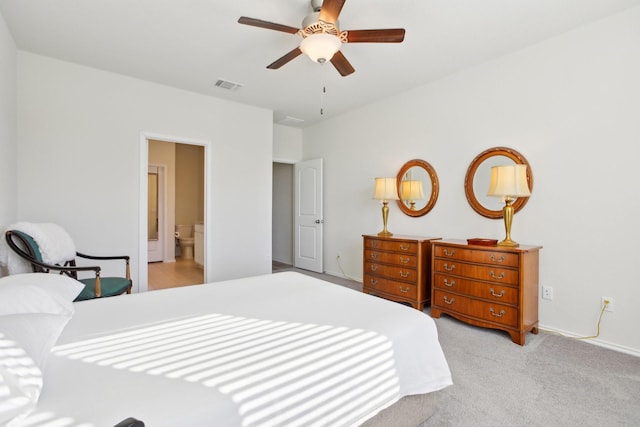 carpeted bedroom with ceiling fan and ensuite bath