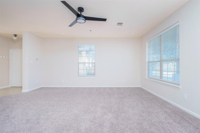 spare room with ceiling fan and light colored carpet