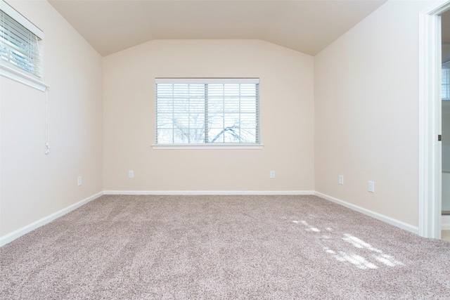 carpeted empty room with vaulted ceiling