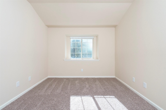 carpeted spare room with lofted ceiling