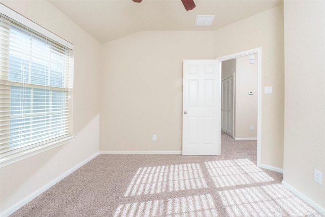 carpeted empty room with ceiling fan and plenty of natural light