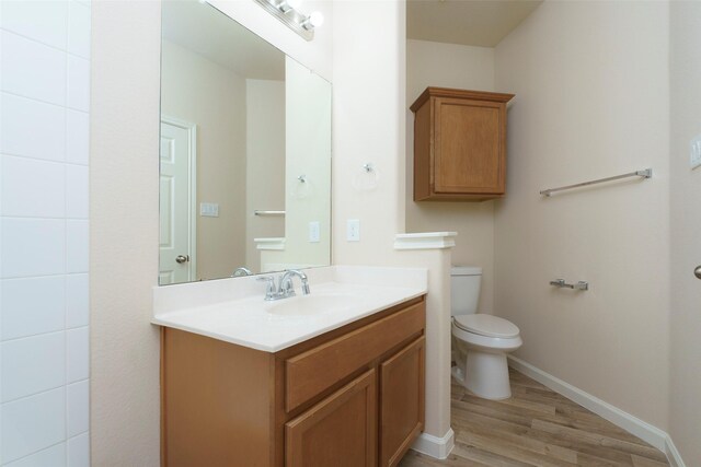 bathroom featuring toilet, vanity, and hardwood / wood-style flooring