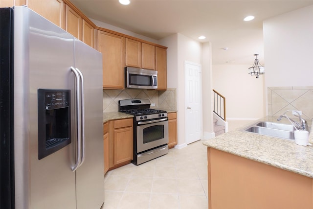 kitchen featuring light tile patterned floors, appliances with stainless steel finishes, decorative backsplash, pendant lighting, and sink