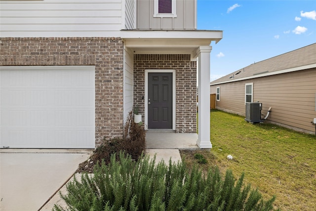 entrance to property featuring central air condition unit and a lawn