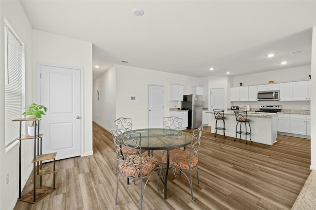 dining space with light hardwood / wood-style floors