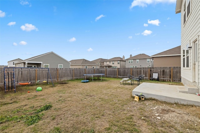 view of yard featuring a trampoline and a patio