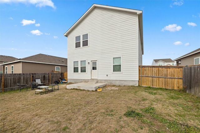 rear view of house featuring a lawn and a patio