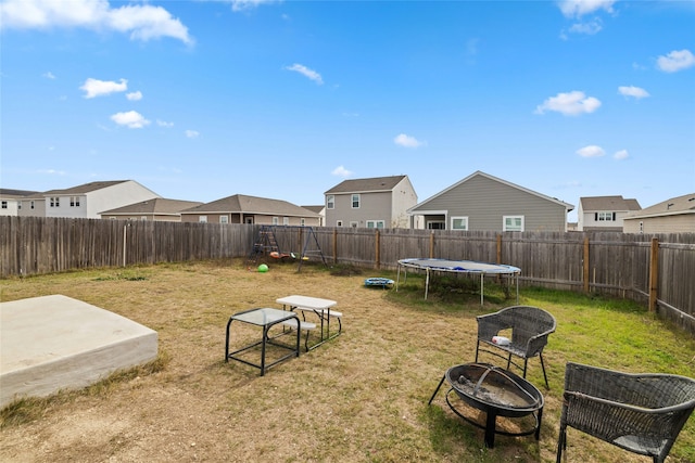 view of yard featuring an outdoor fire pit and a trampoline