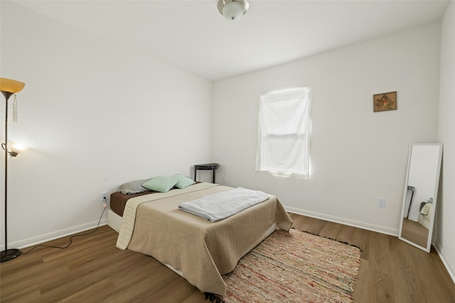 bedroom with dark hardwood / wood-style floors