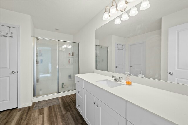 bathroom featuring hardwood / wood-style floors, an enclosed shower, and vanity