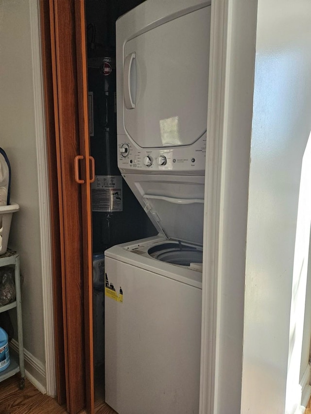 clothes washing area featuring stacked washer and dryer and hardwood / wood-style floors