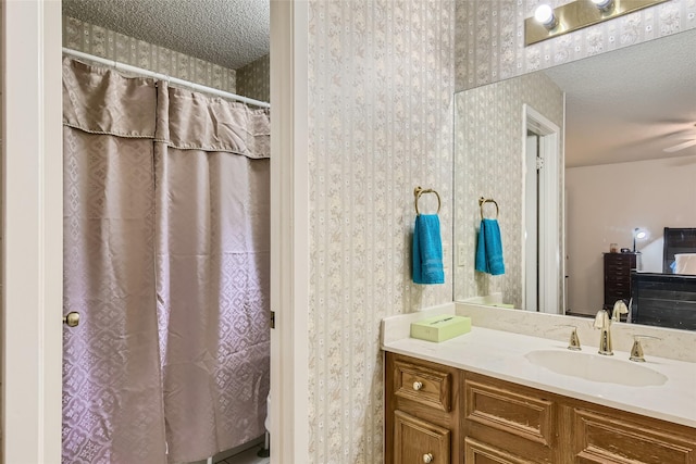 bathroom with curtained shower, a textured ceiling, and vanity