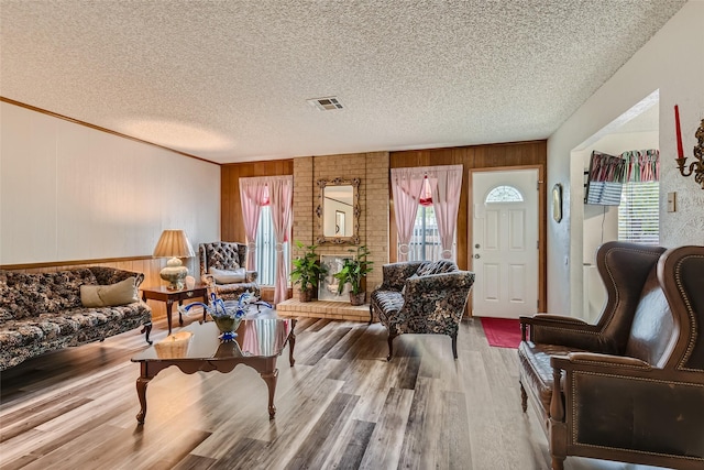 living room featuring hardwood / wood-style flooring, a textured ceiling, and wood walls