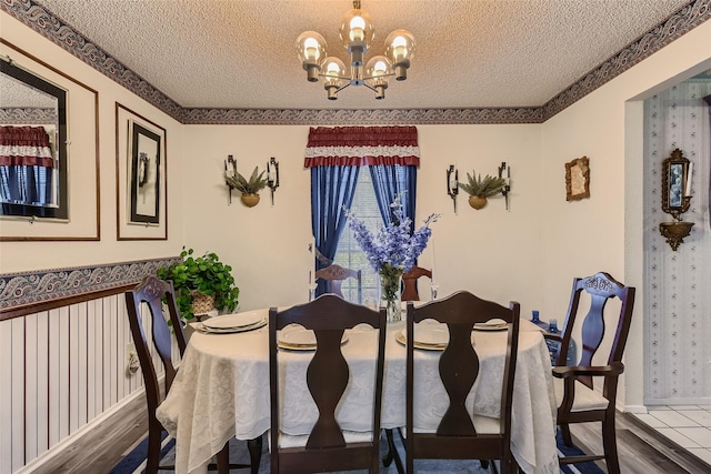 dining area featuring a textured ceiling, a chandelier, and hardwood / wood-style flooring