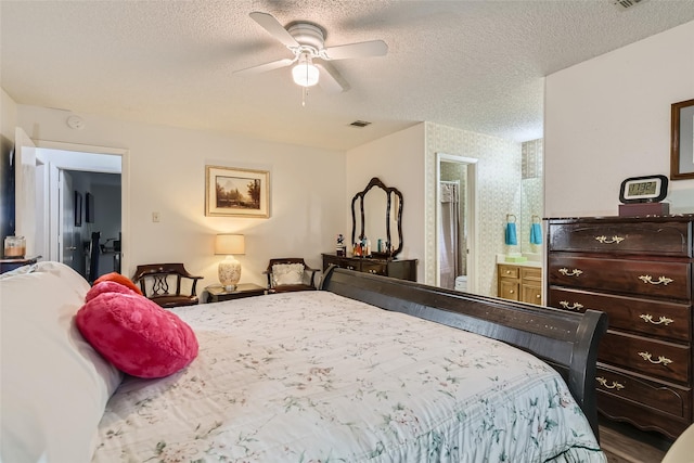 bedroom featuring a textured ceiling, ceiling fan, and ensuite bath