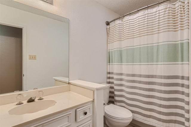 bathroom featuring a textured ceiling, toilet, and vanity