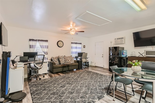 living room featuring ceiling fan, hardwood / wood-style floors, and a wall unit AC