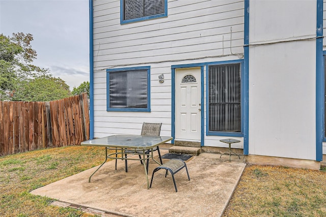 entrance to property with a lawn and a patio area