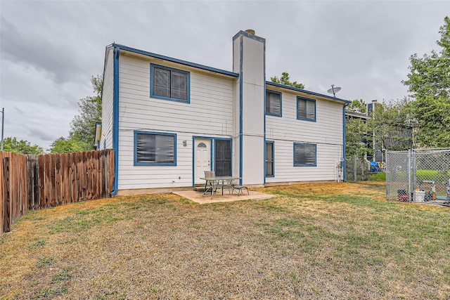 rear view of house with a patio area and a yard