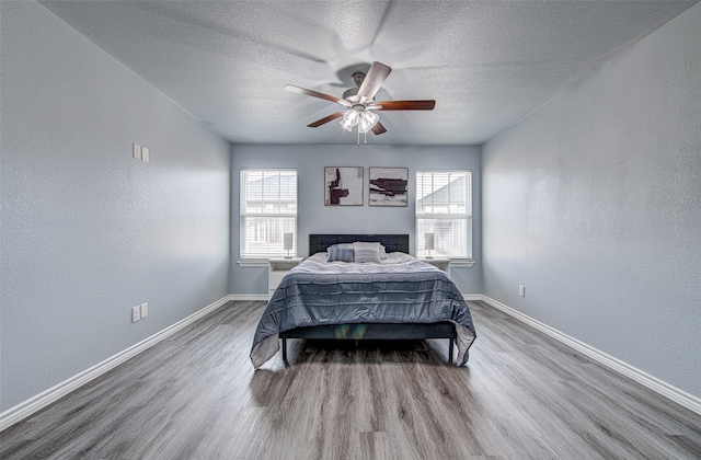 bedroom featuring a textured ceiling, ceiling fan, and hardwood / wood-style flooring