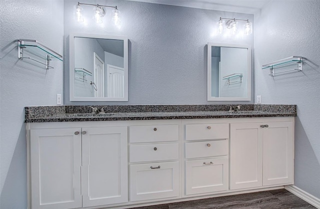 108 Elmer Ave, Burnet, TX 78611 - full bath with double vanity, wood finished floors, and a textured wall