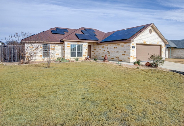 ranch-style house featuring a garage, a front yard, and solar panels