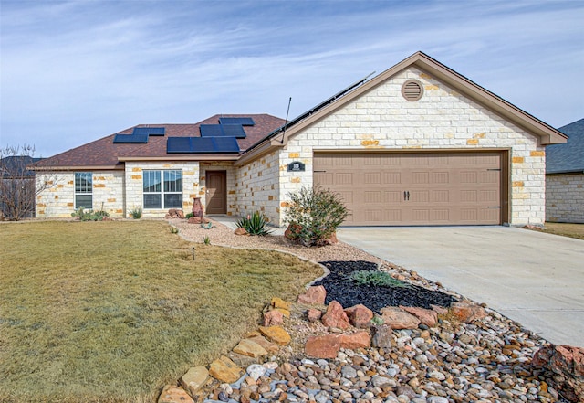 ranch-style home with a garage, a front yard, and solar panels