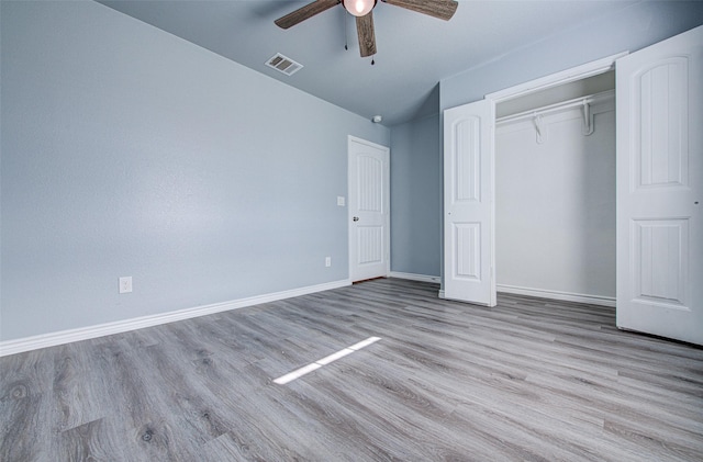 unfurnished bedroom featuring lofted ceiling, ceiling fan, a closet, and light hardwood / wood-style flooring