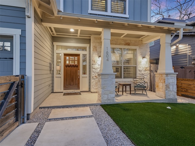 view of exterior entry featuring covered porch