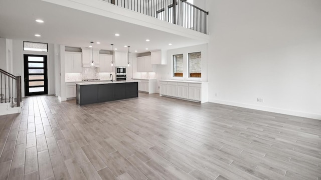 330 Allegheny Way, Kyle, TX 78640 - unfurnished living room featuring a sink, stairs, recessed lighting, and light wood-style floors