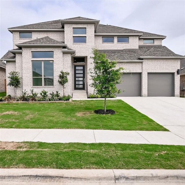 330 Allegheny Way, Kyle, TX 78640 - prairie-style home with concrete driveway, a front lawn, an attached garage, brick siding, and a shingled roof