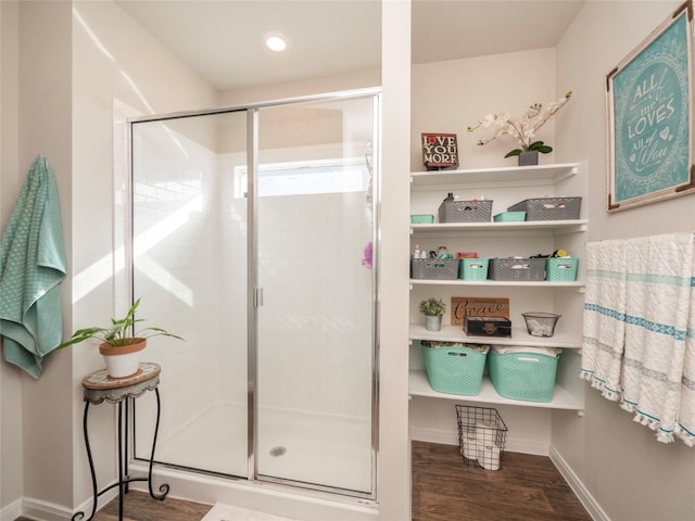 bathroom featuring wood-type flooring and a shower with shower door