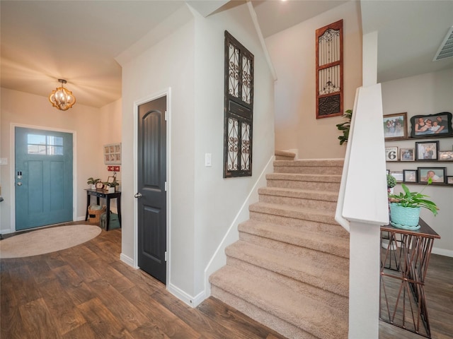 foyer entrance with dark hardwood / wood-style floors and a notable chandelier