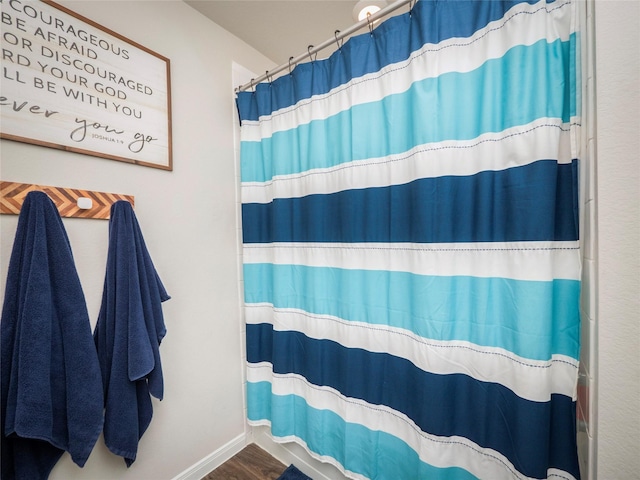 bathroom with curtained shower and hardwood / wood-style floors