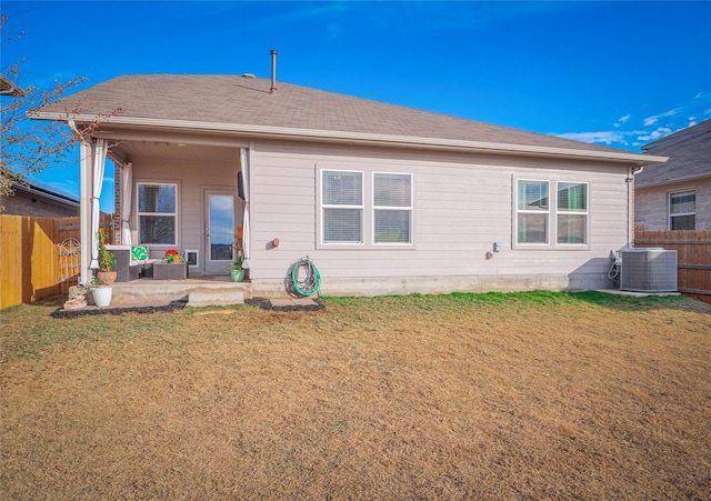 rear view of property with a patio, a yard, and central air condition unit