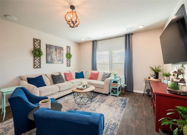 living room with dark wood-type flooring and a notable chandelier