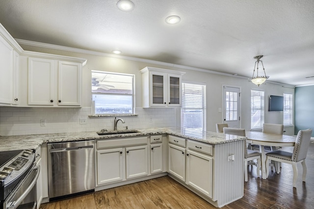 kitchen with stainless steel appliances, decorative backsplash, white cabinetry, and sink