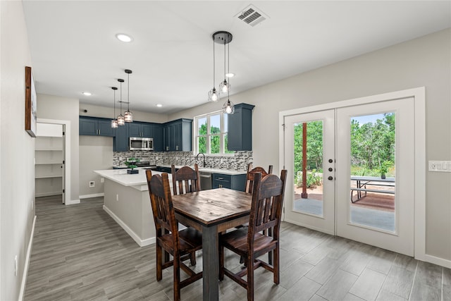 dining room with visible vents, light wood-style flooring, french doors, and baseboards