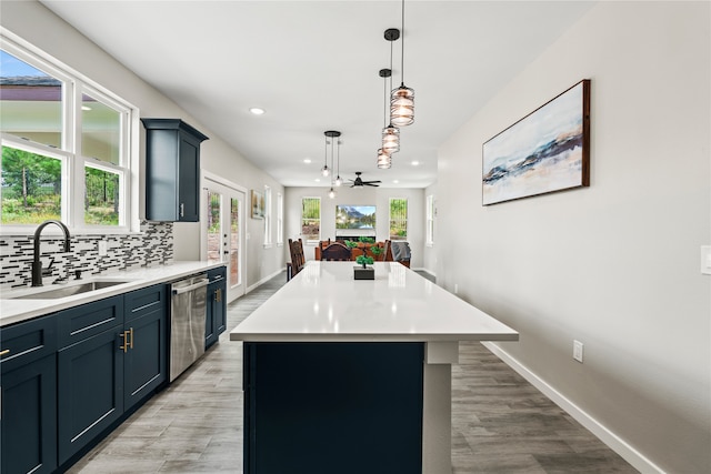 kitchen with a sink, light countertops, french doors, stainless steel dishwasher, and tasteful backsplash