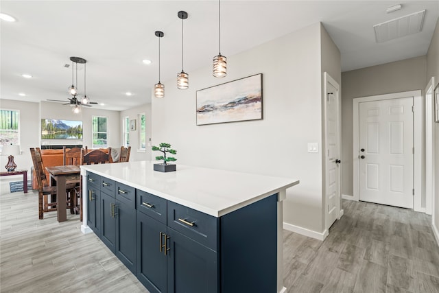 kitchen featuring light countertops, light wood-style flooring, visible vents, and a kitchen island