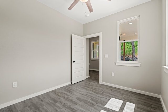 unfurnished room featuring ceiling fan, baseboards, and wood finished floors