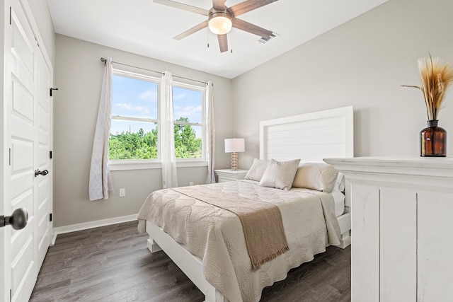 bedroom featuring visible vents, a ceiling fan, baseboards, and dark wood-style flooring