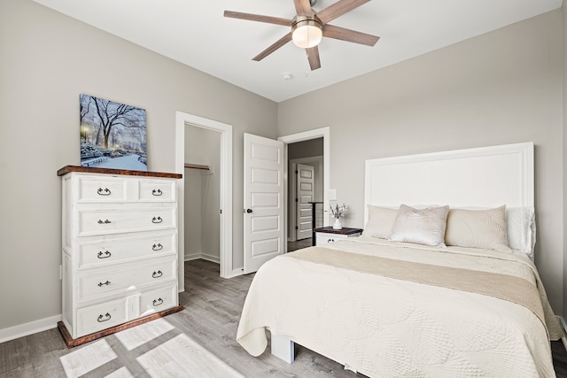 bedroom featuring a ceiling fan, baseboards, and light wood-type flooring