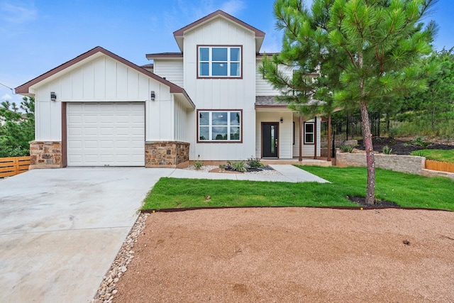 view of front of home featuring a front lawn, concrete driveway, a garage, stone siding, and board and batten siding