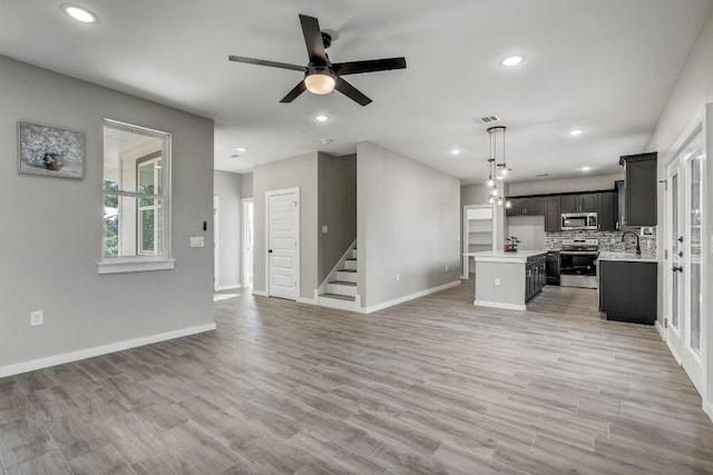 108 Kimo Ct, Bastrop, TX 78602 - unfurnished living room with a ceiling fan, baseboards, stairway, recessed lighting, and light wood-style floors
