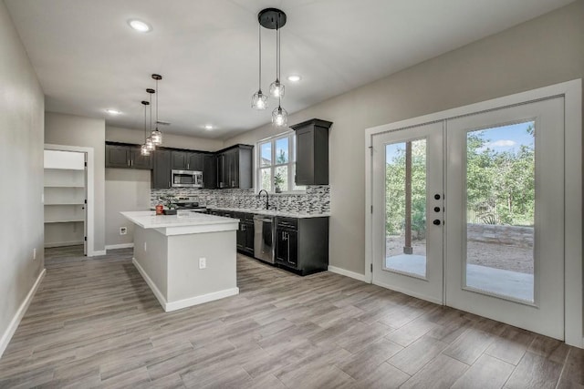 108 Kimo Ct, Bastrop, TX 78602 - kitchen featuring stainless steel appliances, french doors, decorative backsplash, light wood-style floors, and light countertops