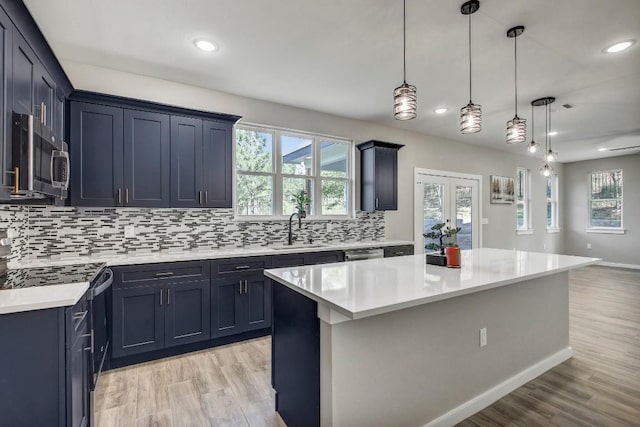 108 Kimo Ct, Bastrop, TX 78602 - kitchen featuring stainless steel microwave, range, a sink, tasteful backsplash, and light countertops