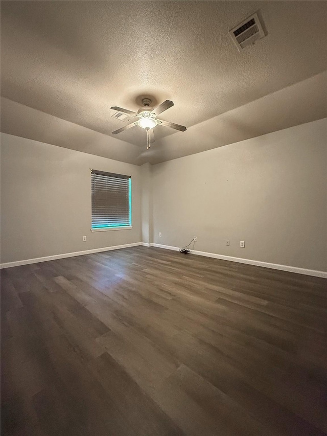 spare room with ceiling fan, dark wood-type flooring, and a textured ceiling