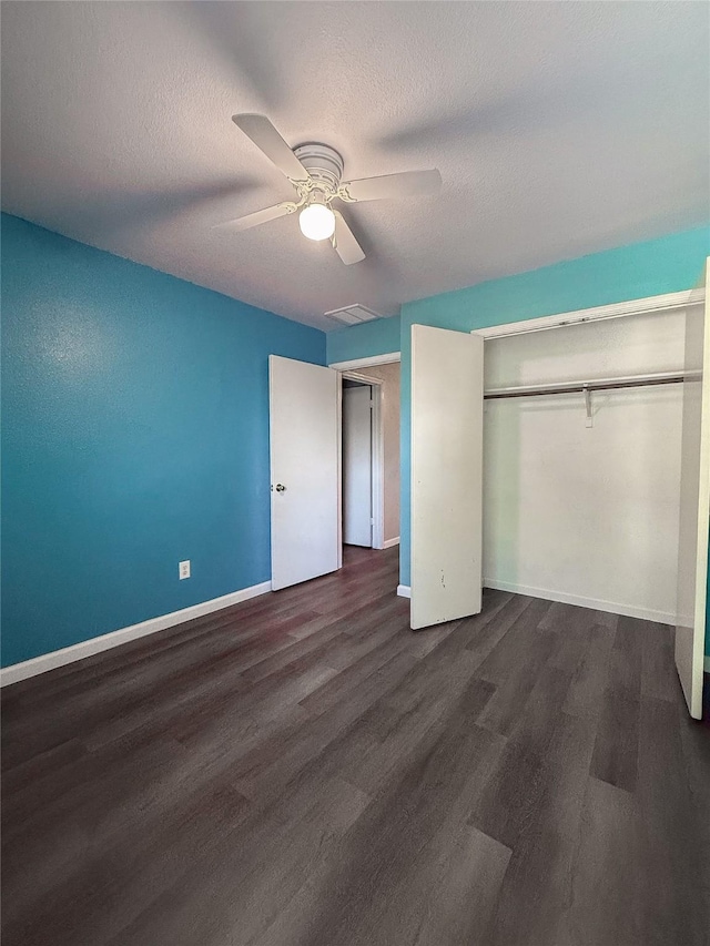 unfurnished bedroom featuring ceiling fan, a textured ceiling, dark hardwood / wood-style floors, and a closet